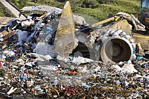 Heavy machinery shredding garbage in an open air landfill. Pollution