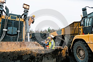 Heavy machinery and workers in pit of quarry