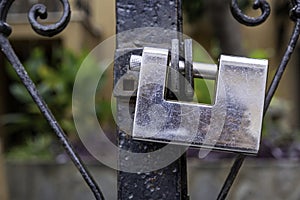 Heavy metal padlock closeup on a brown color entrance gate
