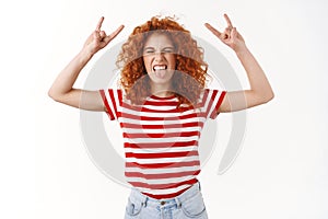 Heavy metal rock party. Playful carefree happy redhead curly-haired young outgoing woman close eyes show tongue thrilled