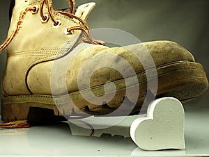 Heavy military boot trampling heart.