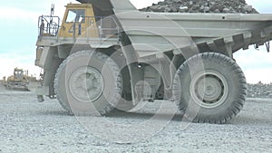 Heavy mining dump trucks moving along the opencast