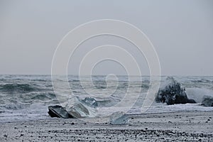 Heavy ocean waves crash onto ice floes from calved glaciers