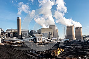 Heavy plant machinery loading coal to burn in a coal fired power station