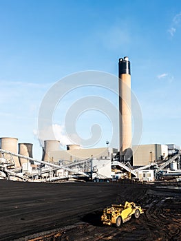 Heavy plant machinery loading coal to burn in a coal fired power station