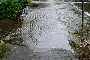 Heavy rain caused flooding over sidewalk, grass strip, and road