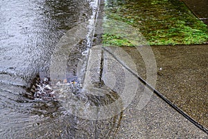 Heavy rain caused flooding in street, water swirling around storm drain