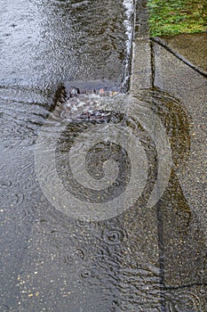 Heavy rain caused flooding in street, water swirling around storm drain