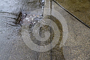 Heavy rain caused flooding in street, water swirling around storm drain