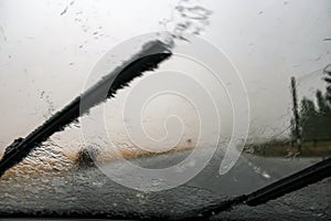 Heavy rain. Cloudburst on windshield. Windscreen wiper photo