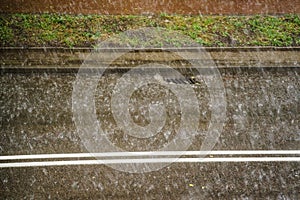 Heavy rain drops falling on city street