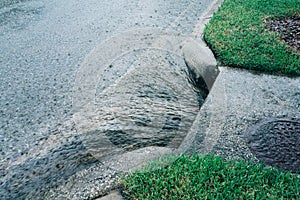 Heavy rain flowing through sewer drain.