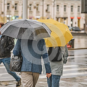 Heavy rain, people under open umbrellas