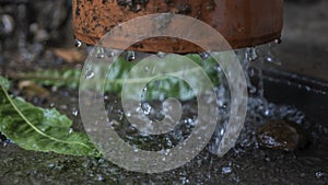 Heavy rain. Rainwater flows from the roof through the drainpipe. Rainy season