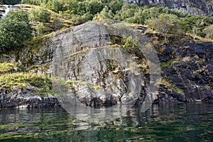 Heavy rocks water reflection in norwegian fjord