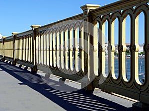 Heavy and rugged cast iron yellow color bridge railing with strong shadow