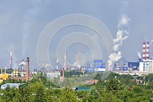 Heavy smoke industrial chimneys causing air pollution problems. Emissions are visible over residential areas of the city.