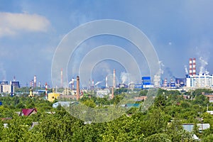 Heavy smoke industrial chimneys causing air pollution problems. Emissions are visible over residential areas of the city.