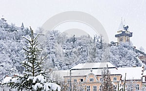 Heavy snow and the famous clock tower on Schlossberg hill, in Graz, Steiermark region, Austria. Selective focus