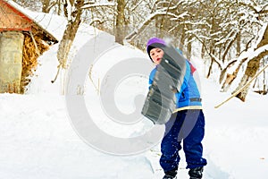 After heavy snow, the little boy clears the snow with a shovel