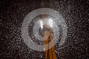 Heavy snowfall at night under the light of a lantern