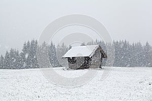 Heavy snowstorm over old wooden hut