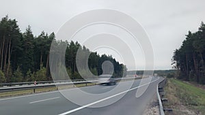 Heavy traffic on the freeway. Road goes beyond the horizon Pine forest TimeLapse