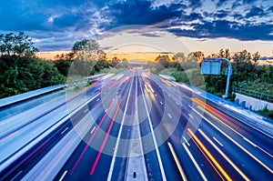 Heavy traffic moving at speed on UK motorway in England at sunset