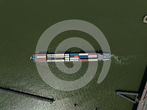 Heavy transport container bulk carrier freighter overhead top down view on sea lake open water isolated. Commercial