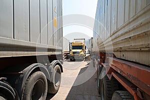 Heavy trucks loaded with goods trailers, parked in waiting area on state border crossing in Vietnam