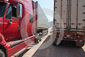 Heavy trucks loaded with goods trailers, parked in waiting area on state border crossing in Vietnam