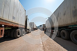 Heavy trucks loaded with goods trailers, parked in waiting area on state border crossing in Vietnam