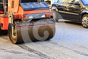 Heavy vibrating road roller stands on the roadway