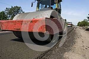 Heavy Vibration roller at asphalt pavement working on the new road construction site. Repairing.