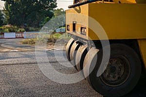 Heavy vibration yellow steamroller or soil compactor working on hot-mix asphalt pavement road