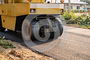 Heavy vibration yellow steamroller or soil compactor working on hot-mix asphalt pavement road