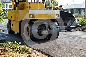 Heavy vibration yellow steamroller or soil compactor working on hot-mix asphalt pavement road