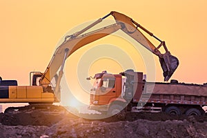 Heavy wheel excavator machine working at sunset