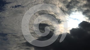 Heavy white overlapping clouds with glaring bright sun, scorching heat. Cumulus cloud cloudscape