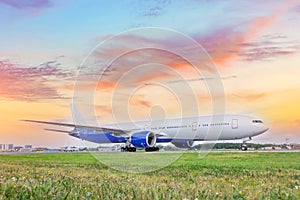 Heavy wide-body long-haul jet aircraft taxis to the runway for takeoff, against the backdrop of a beautiful dawn sunset sky