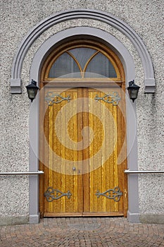 Heavy wooden arched door with ornate hinges