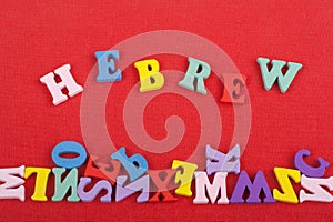 HEBREW word on red background composed from colorful abc alphabet block wooden letters, copy space for ad text. Learning english