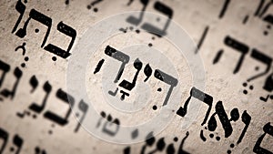 Hebrew word in Torah page. English translation is name Dinah. Daughter of Jacob and Leah. Selective focus. Closeup photo