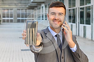 Hectic businessman multitasking with two smartphones