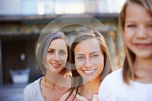 Heed the wisdom of previous generations. Portrait of a grandmother, mother and daughter outside.