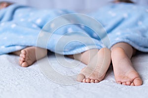 Heels and toes on bed. Heels and feets. Children`s feet. Barefeet on the bed. Kid`s feet in bed. Kids taking a rest