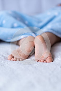 Heels and toes on bed. Heels and feets. Children`s feet. Barefeet on the bed. Kid`s feet in bed. Kids taking a rest