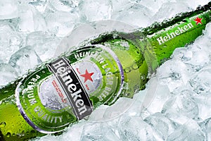 Frosty Heineken beer bottle laying on ice cubes