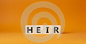 Heir symbol. Concept word Heir on wooden cubes. Beautiful orange background. Business and Heir concept. Copy space