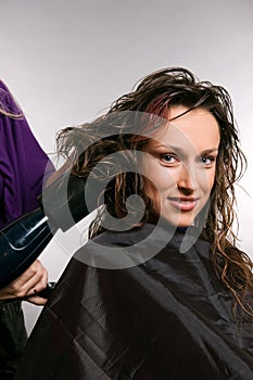 Heirdresser blow-dry hair of client